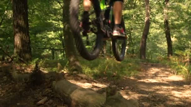 LÅG ANGLE: Ung man längdcyklist rider sin cykel ner en grusväg. — Stockvideo