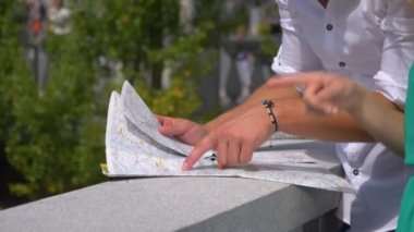 Tanınmayan turistler eski bir kasabayı keşfederken haritaya bakarlar..