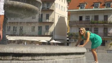 Kadın, Ljubljana 'ya yaptığı bir gezi sırasında erkek arkadaşına su sıçratıyor..