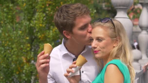 SLOW MOTION: Gelukkig man kust zijn vriendin op het voorhoofd tijdens het eten van gelato — Stockvideo