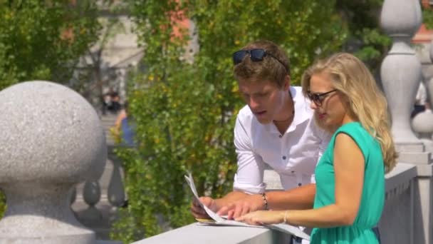 MANOS: Mujer joven y su novio observan la ciudad mientras miran un mapa . — Vídeos de Stock