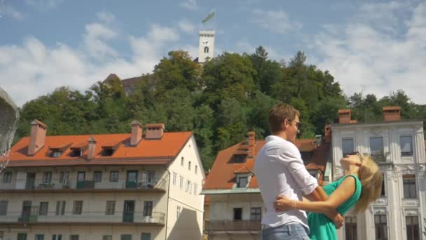 Медленное движение: веселая пара туристов вращается вокруг солнечных улиц Любляны — стоковое видео