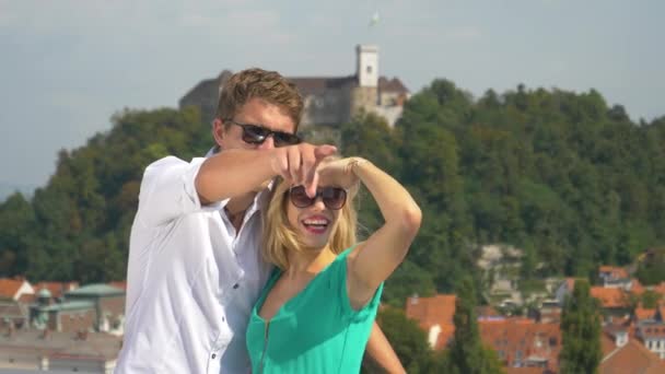 Улыбающаяся пара наблюдает живописный городской пейзаж Любляны в солнечный день . — стоковое видео