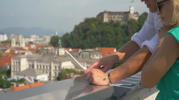 FERMER : Couple de touristes joyeux naviguer sur la carte et le paysage urbain à partir d'un toit . — Video