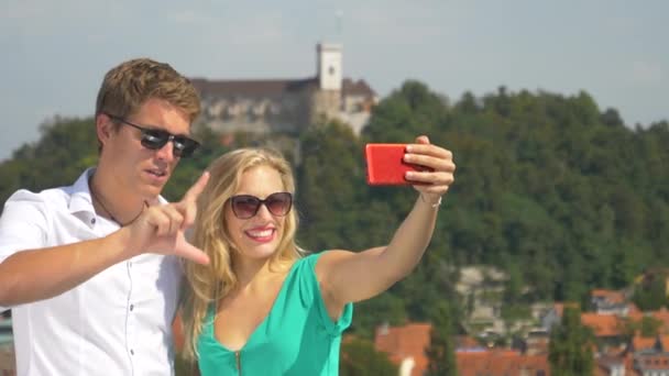 CLOSE UP: Woman holds up her cell phone while shooting a vlog with her boyfriend — Stock Video