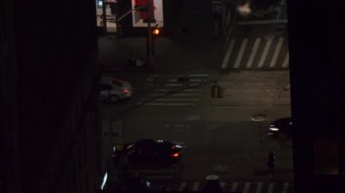 Yayalar New York 'ta gece vakti yoğun bir ana yol boyunca yürürler..