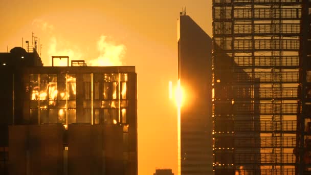 Sluiten: Spectaculaire gouden zonsopgang verlicht de ontwikkeling van appartement wolkenkrabber — Stockvideo