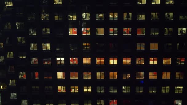 CLOSE UP: People extending their workdays late into the night in glassy building — Stock Video