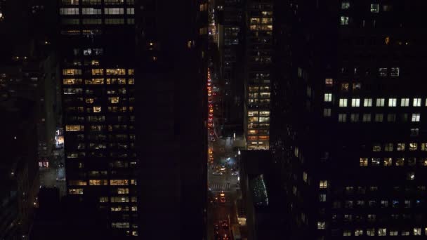 Vielbefahrene Straßen schlängeln sich zwischen beleuchteten Wolkenkratzern in einer geschäftigen Großstadt. — Stockvideo