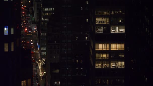 Jen málo kanceláří v korporátní budově je osvětleno během rušné noci v New Yorku — Stock video