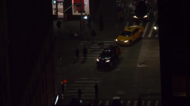 FECHAR UP: As pessoas atravessam a estrada de asfalto, enquanto os carros passam durante uma noite agitada . — Vídeo de Stock