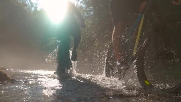 太陽のフレア: 2人の男性が川を渡ってサイクルとして川を照らすブラインドサンビーム. — ストック動画
