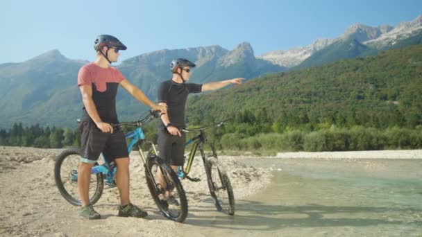 MOCIÓN LENTA: Chicos montando bicicletas eléctricas hablando y planeando su ruta . — Vídeos de Stock