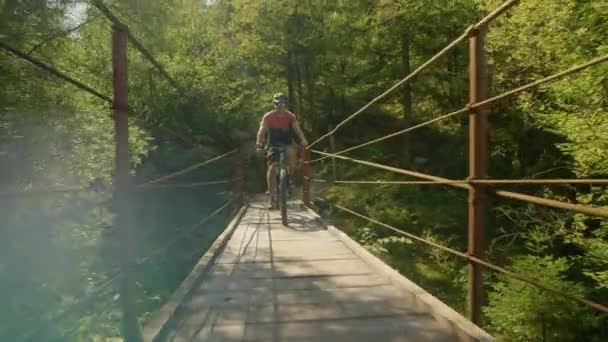 SLOW MOTION: Dois amigos cruzam uma ponte enquanto andam de bicicleta elétrica no verão — Vídeo de Stock