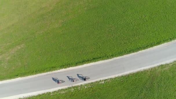 TOP DOWN: Actieve toeristen ontdekken het schilderachtige landschap op de fiets. — Stockvideo