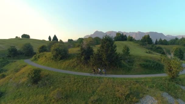 DRONE: Espectacular paisaje de montaña rodea a los viajeros montando bicicletas eléctricas . — Vídeo de stock