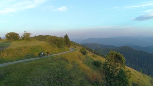 AERIAL: Volando sobre tres amigos en bicicleta de montaña explorando el paisaje rural — Vídeos de Stock