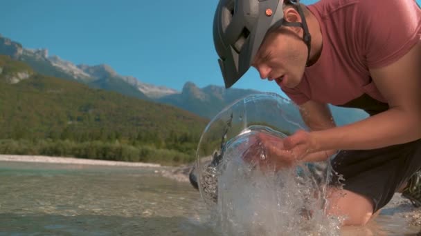 CLOSE UP Mountain motoros megáll útja során, hogy mossa meg arcát üveges vízzel — Stock videók