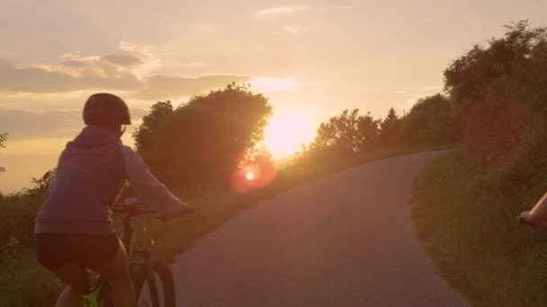 MOCIÓN LENTA: Jóvenes viajeros disfrutan de un viaje en bicicleta en una mañana soleada . — Vídeos de Stock