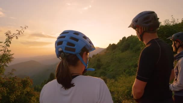 SUN FLARE: Glada turister knytnäve bula vid solnedgången efter en framgångsrik cykel resa. — Stockvideo