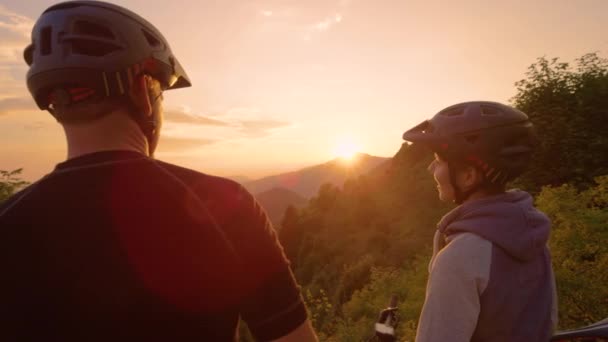 CLOSE UP: Glad man och kvinna bula knytnävar efter en naturskön cykeltur vid solnedgången. — Stockvideo