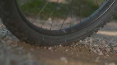 Dağ bisikletçisi fren yaparken havada küçük kayalar uçuşuyor..