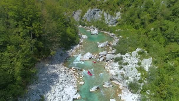AERIAL: Туристы на байдарках и сплаве плавают вокруг изумрудной реки. — стоковое видео