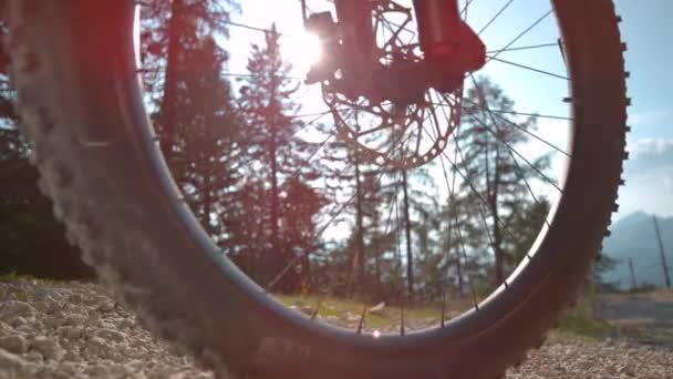 FLARE DE LA LENTE: Frenos de hombre irreconocibles mientras se conduce una bicicleta por la pista de grava. — Vídeo de stock