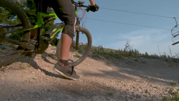 Movimiento lento: Dos amigos frescos corren a lo largo de la pista de grava en sus bicicletas de montaña . — Vídeo de stock