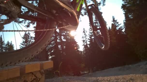 CLOSE UP Onherkenbare man op elektrische fiets springt als hij rijdt langs een onverharde weg — Stockvideo