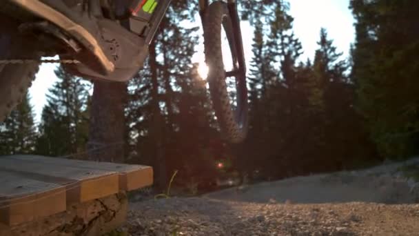 Movimiento lento: plano cinematográfico del ciclista de montaña saltando de un pateador de madera . — Vídeos de Stock