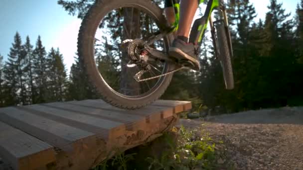 FLARE SOL: Los ciclistas de montaña salen de una rampa en medio de una pista de grava. — Vídeos de Stock