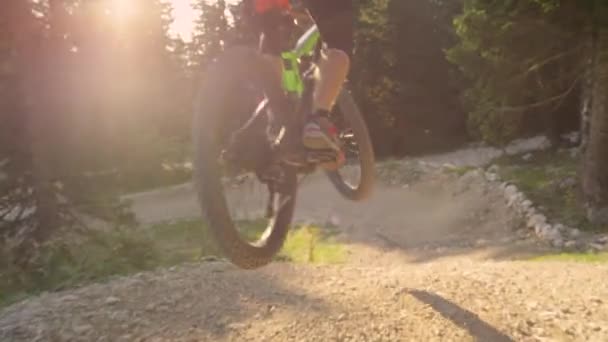 SUN FLARE: downhill cyklist hoppar av en kicker och rider mot en skarp sväng. — Stockvideo