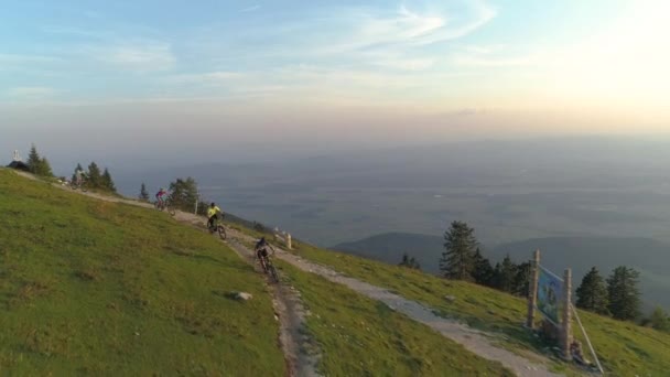 AERIAL: Voando acima de quatro amigos montando suas bicicletas de montanha para baixo trilha estreita. — Vídeo de Stock