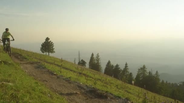 CERRAR: Cuatro amigos en bicicleta de montaña recorren un estrecho sendero de montaña . — Vídeo de stock