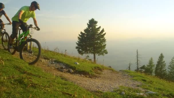 SLOW MOTION: Morgensonne erhellt Landschaft, wenn Radfahrer in Kurve fahren. — Stockvideo