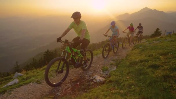 SLOW MOTION: Viaggiatori felici che si godono un giro in bicicletta tra le montagne illuminate dal sole . — Video Stock