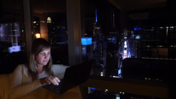 Vrouw beantwoordt een skype oproep tijdens het werken vanuit haar hotel 's nachts. — Stockvideo