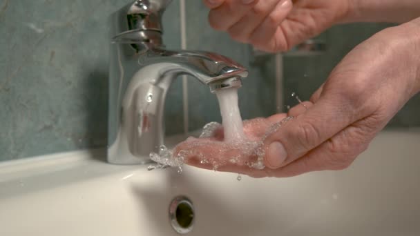 CLOSE UP, DOF: Unerkannte Person öffnet den Wasserhahn und wäscht sich die Hände. — Stockvideo