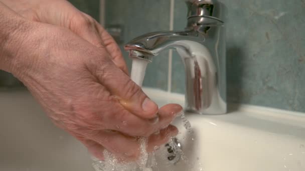 CHIUDI, DOF: L'acqua corrente schizza nella fotocamera mentre la persona si lava le mani — Video Stock