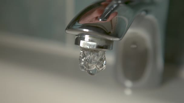 MACRO Água da torneira começa a fluir para a pia branca depois que a pessoa abre a torneira — Vídeo de Stock