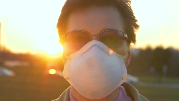 PORTRAIT, DOF: Morning sunbeams shine on elderly female wearing a facemask. — Stock Video