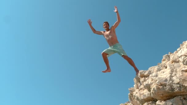 SLOW MOTION : Prise de vue cinématographique d'une joyeuse falaise touristique masculine plongeant en Croatie . — Video