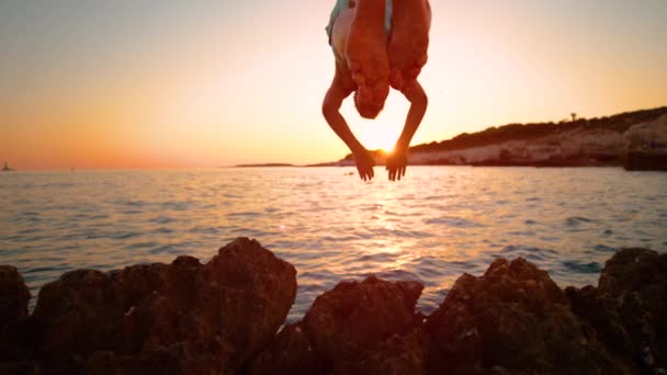 CLOSE UP: Unrecognizable man dives into the ocean on a sunny summer evening. — Stock Video