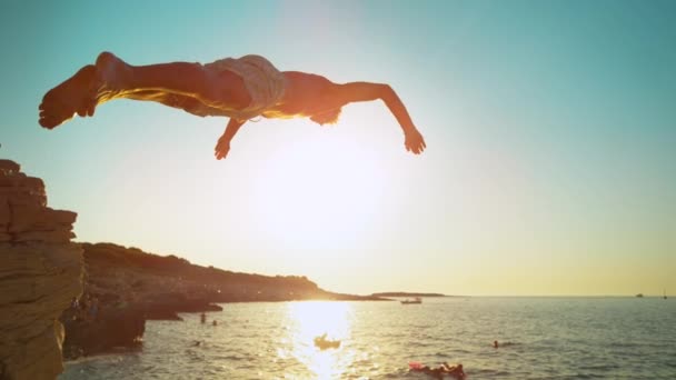 レンズフレア:日没時に男性の観光客がさわやかな海に飛び込むのに適しています. — ストック動画