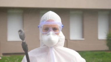Kadın epidemiyoloji uzmanları kameraya sprey sıkar ve sterilize eder..