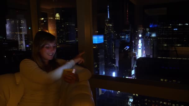 CLOSE UP: Meisje wijst op Times Square terwijl video bellen vrienden 's nachts. — Stockvideo