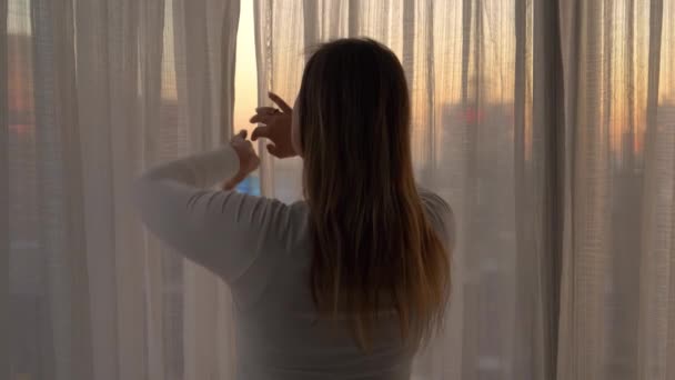 スローモーション幸せな女性旅行者は、ニューヨークで目覚めた後にカーテンを描きます — ストック動画