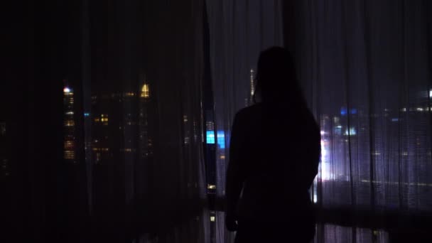 閉じる:認識できない女性観光客はホテルの部屋からタイムズスクエアを見ています. — ストック動画