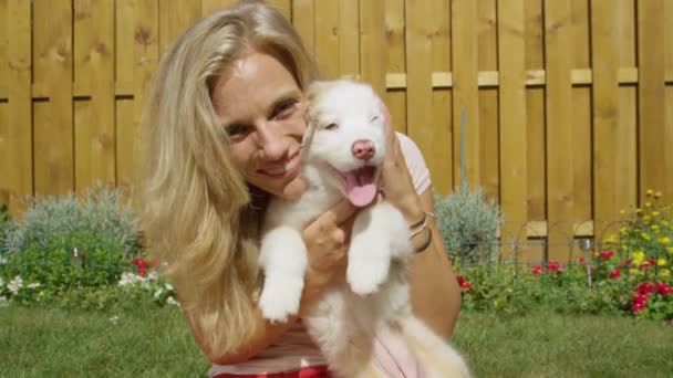 PORTRÄT: Wunderschönes blondes Mädchen spielt im Hinterhof mit ihrem entzückenden Welpen. — Stockvideo